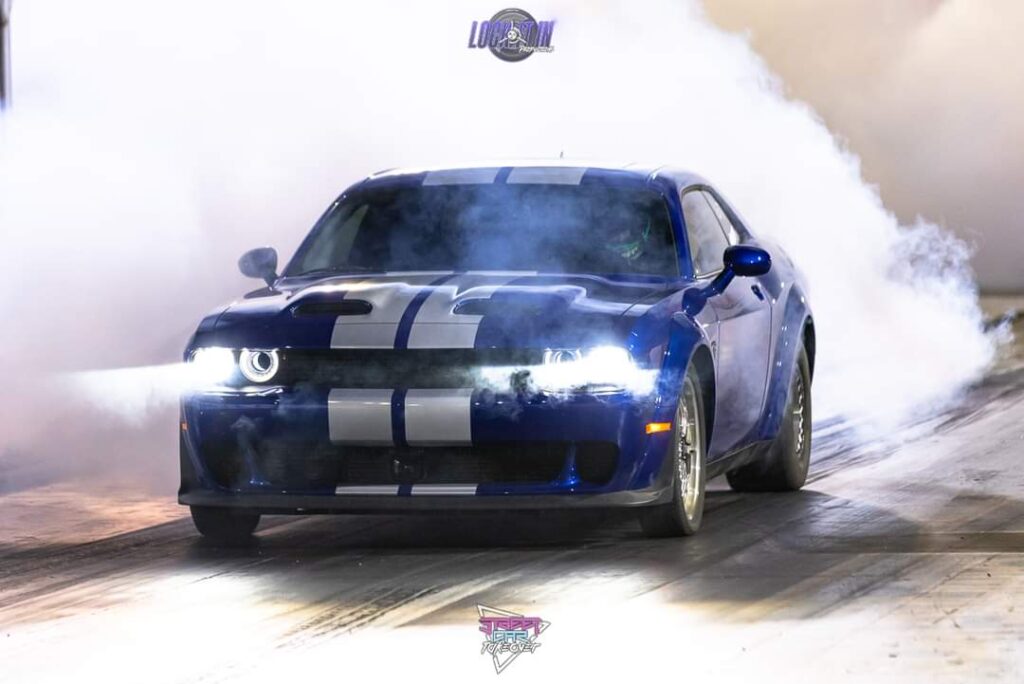 A blue sports car doing a burnout